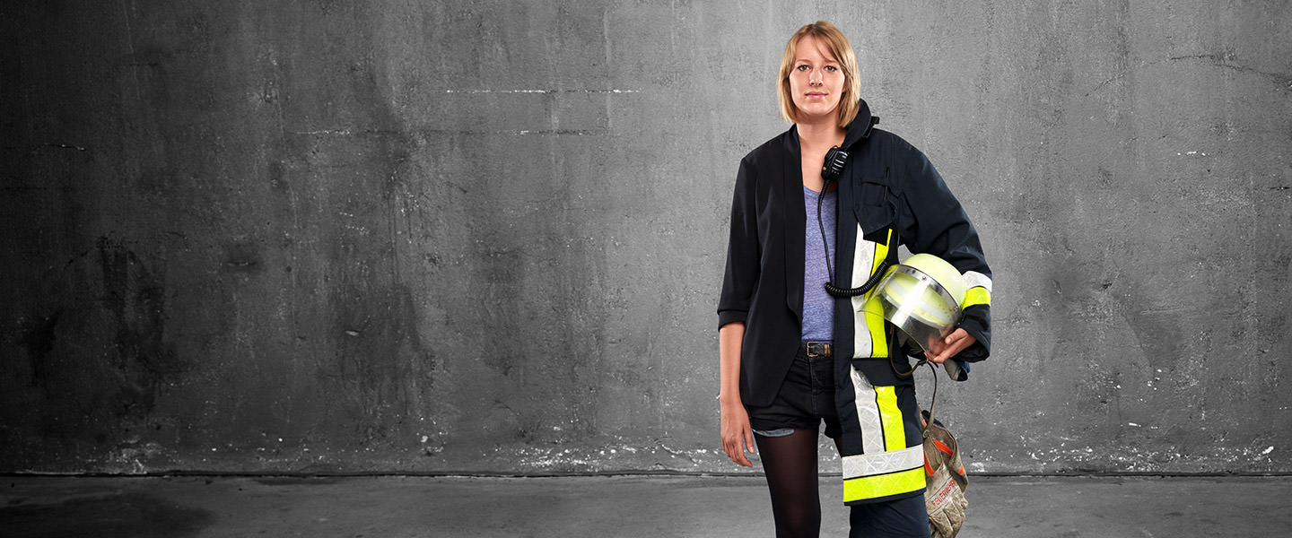 Fotomontage einer Frau: Zur einen Hälfte in legerer Kleidung, zur anderen in Feuerwehruniform.