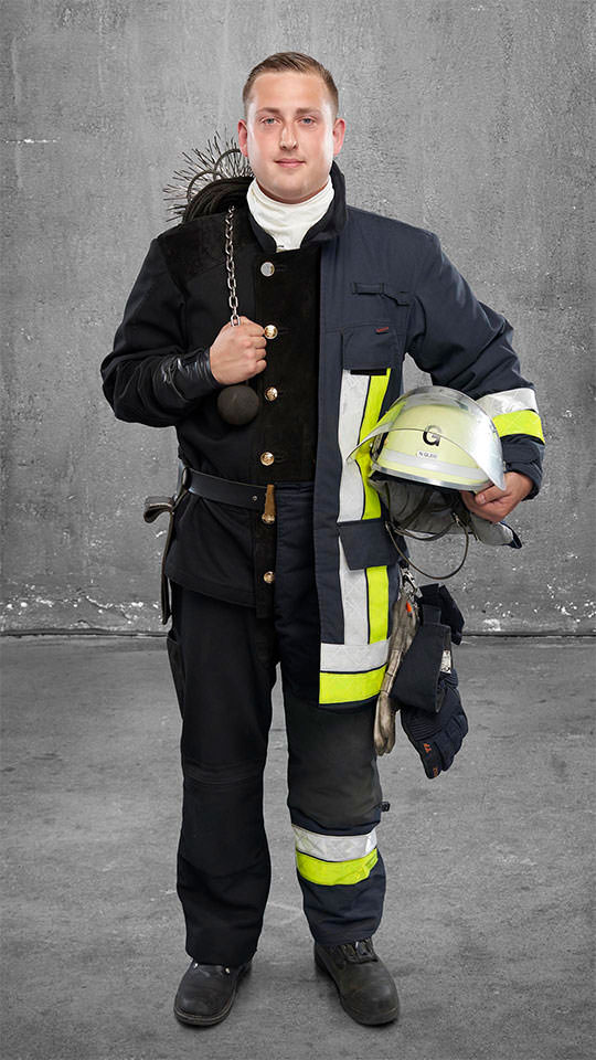 Fotomontage eines Mannes: Halb Schornsteinfeger, halb Feuerwehrmann.